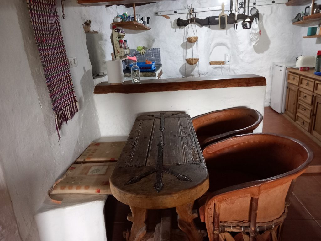 Dining table inside Walnut Cortijo with kitchen behind.