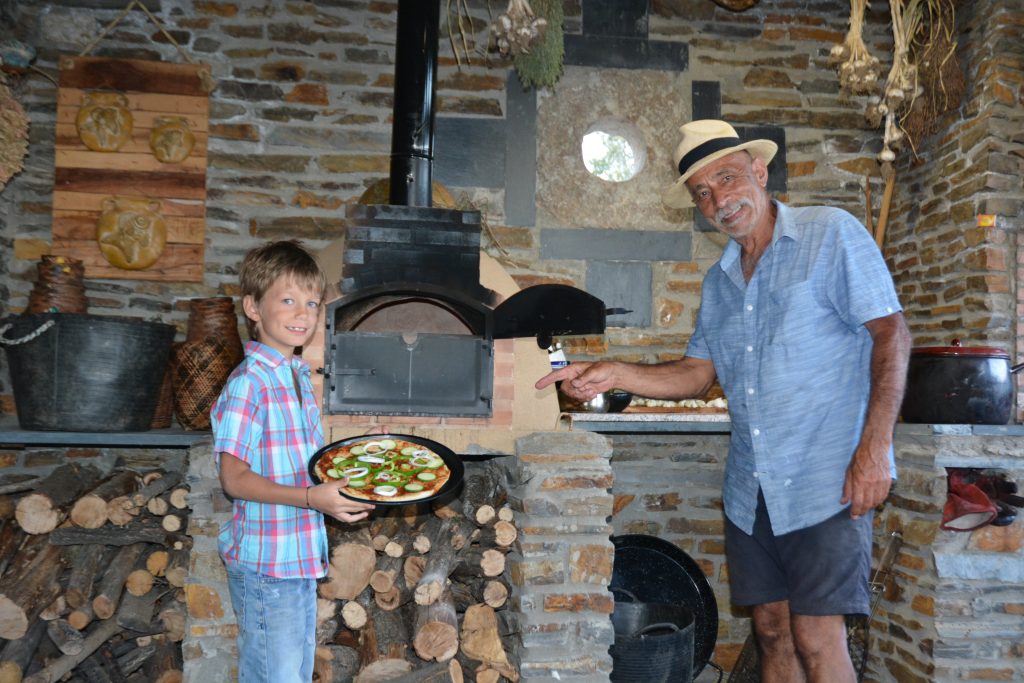 Mo enjoying making pizza in the bread oven with one of our guests.